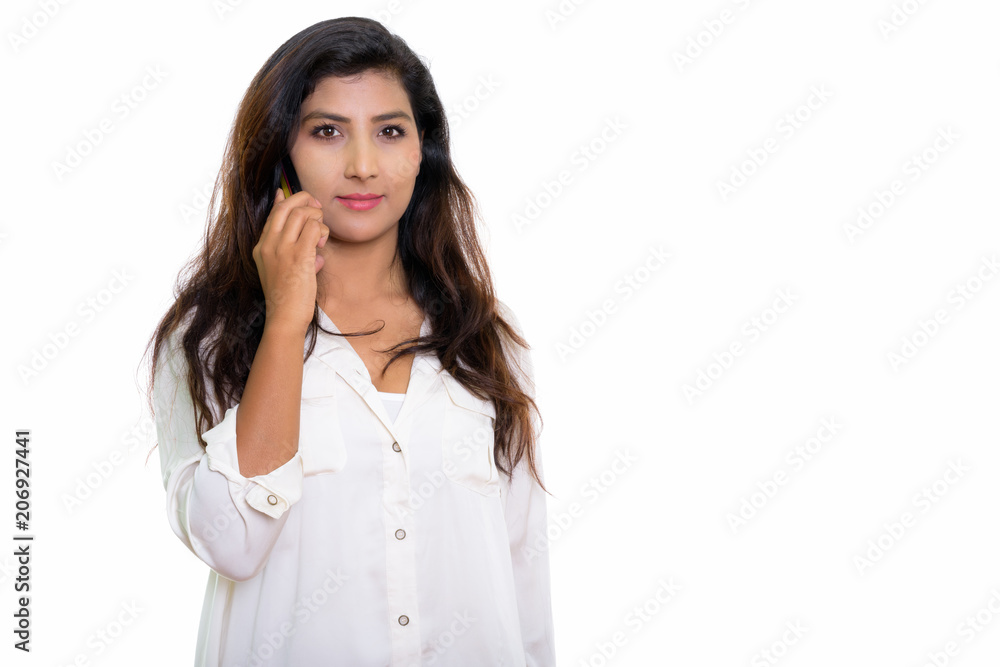 Studio shot of young beautiful Persian woman talking on mobile p Studio shot of young beautiful Persian woman talking on mobile p