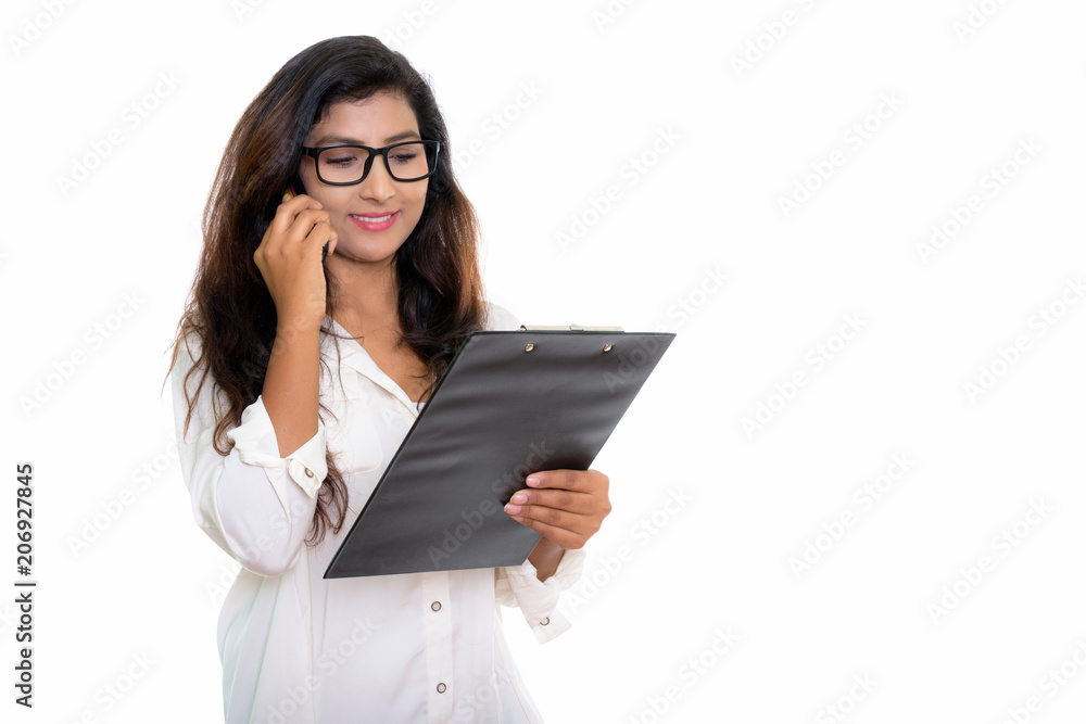 Young happy Persian woman smiling while talking on mobile phone Young happy Persian woman smiling while talking on mobile phone