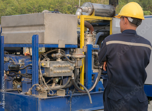 Worker engineer Man work in oil or gas refinery, turning on and off the pipeline valve torso and hand engineer yellow helmet for workers security construction worker .