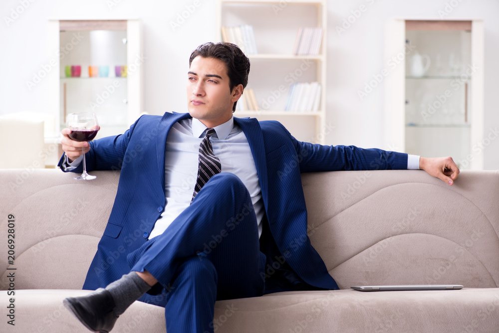 Businessman drinking wine sitting at home Businessman drinking wine sitting at home