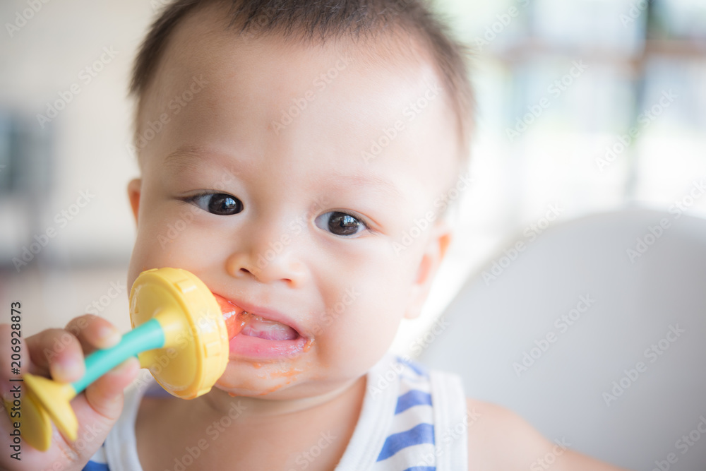 Asian cute baby boy are eating fruit from the accessory. Asian cute baby boy are eating fruit from the accessory.