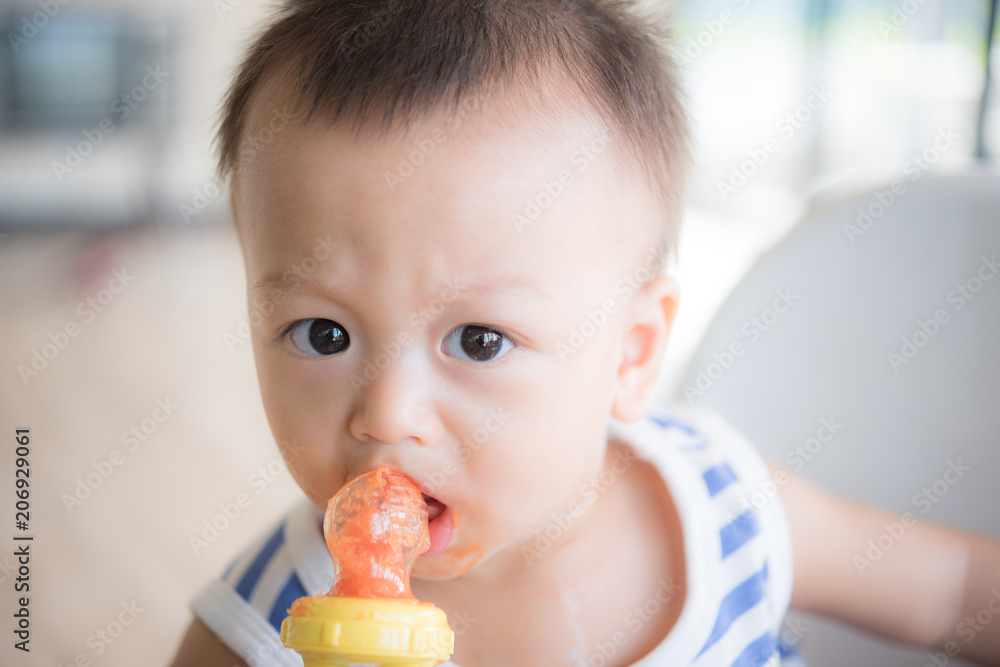 Asian cute baby boy are eating fruit from the accessory. Asian cute baby boy are eating fruit from the accessory.