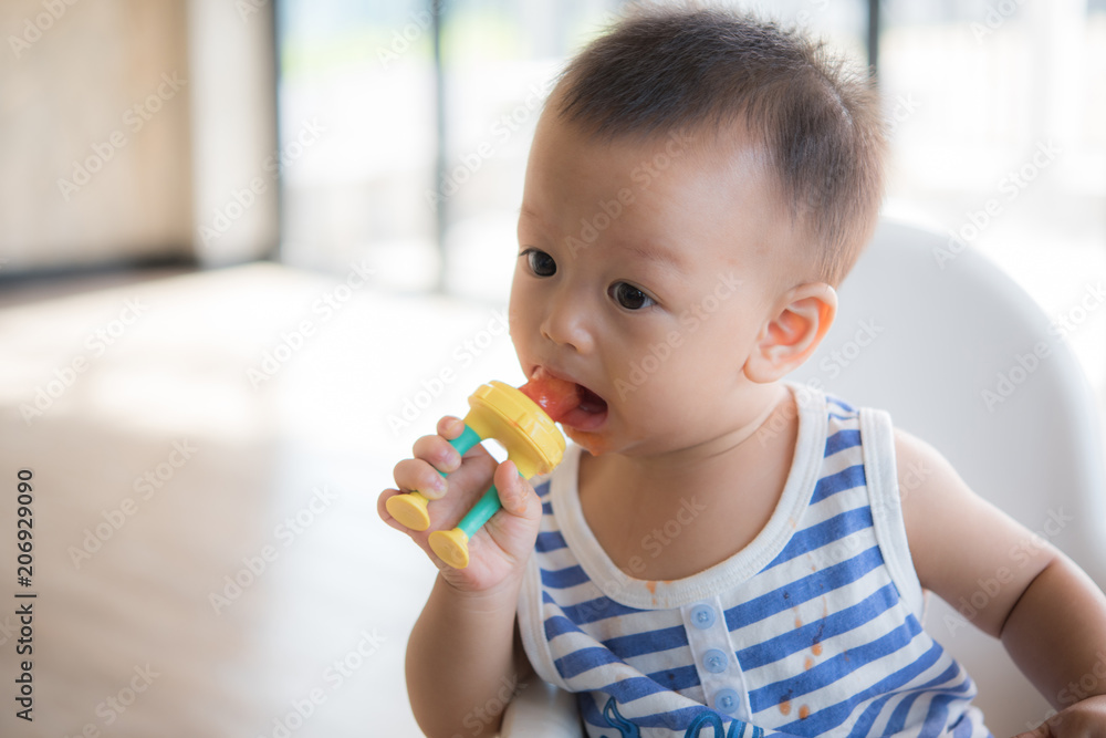 Asian cute baby boy are eating fruit from the accessory. Asian cute baby boy are eating fruit from the accessory.