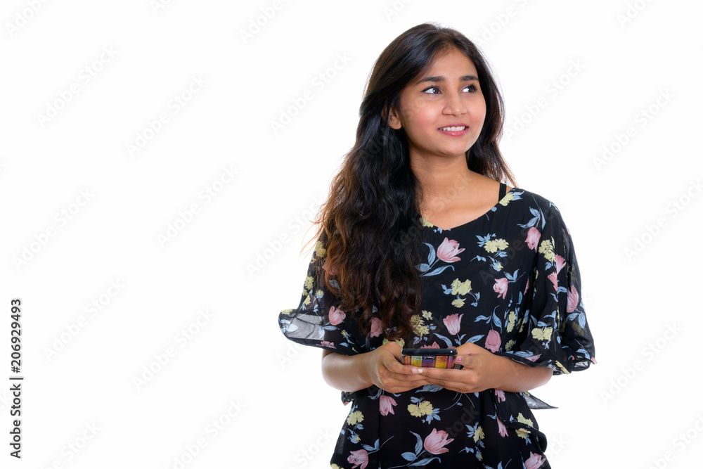 Studio shot of young happy Persian woman smiling while thinking Studio shot of young happy Persian woman smiling while thinking