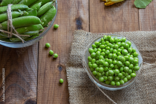a lot of peeled small green young peas in a bowl on the table