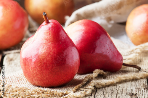 Ripe red pears on rustic wooden background, selective focus