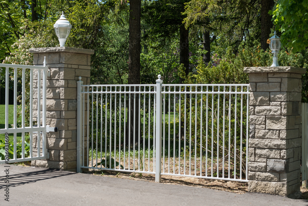 Two pillars and a white metal fence Two pillars and a white metal fence