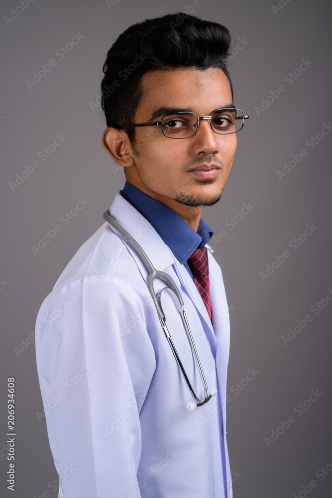Young Indian man doctor against gray background Young Indian man doctor against gray background