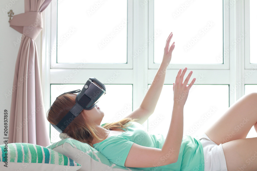 Young woman wearing virtual reality glasses at home. Young woman wearing virtual reality glasses at home.
