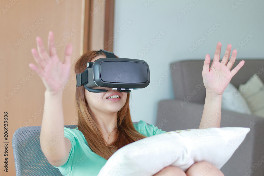 Young woman wearing virtual reality glasses at home. Young woman wearing virtual reality glasses at home.
