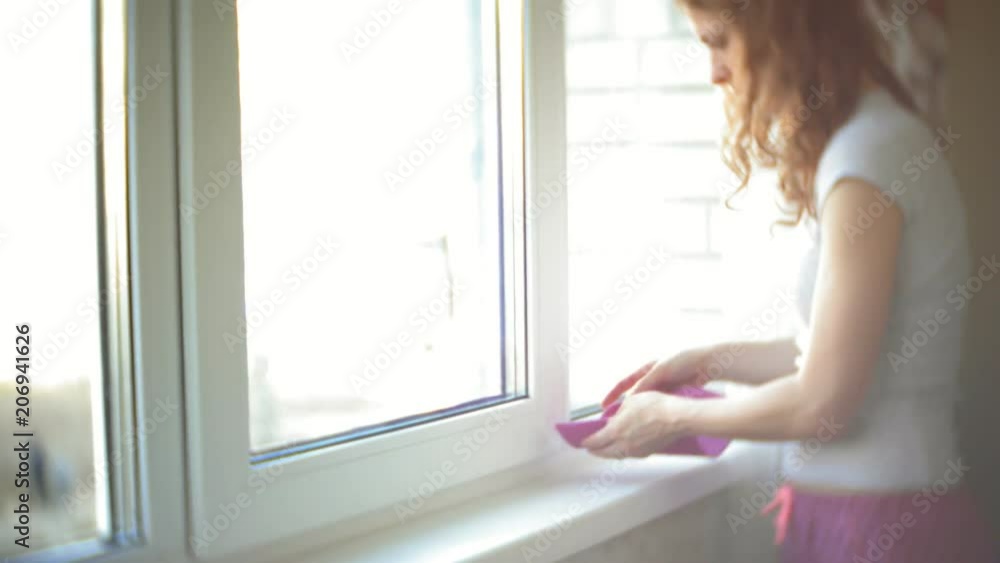 attractive girl washes windows at home. To clean up the house. attractive girl washes windows at home. To clean up the house.