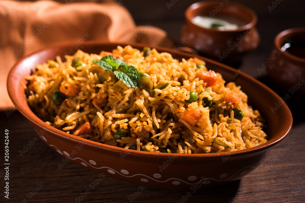 Indian Vegetable Pulav or Biryani made using Basmati Rice, served in terracotta bowl. selective focus