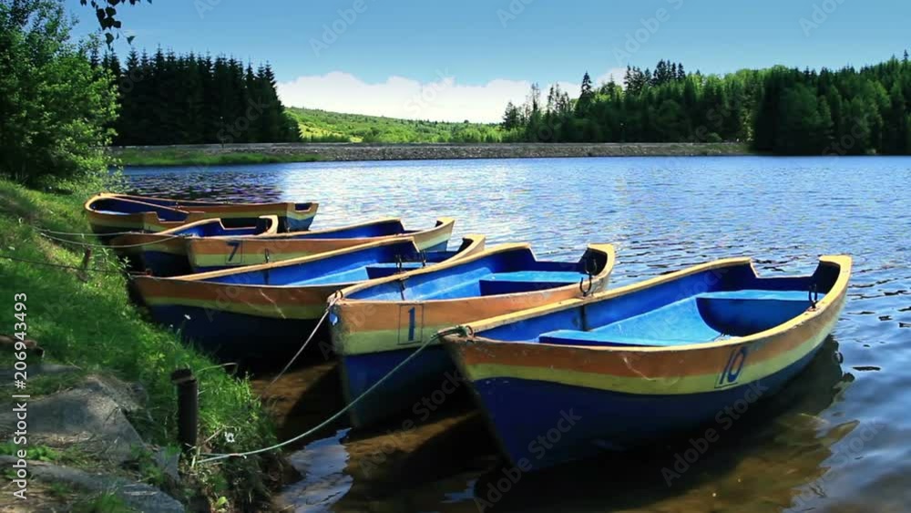 Row Boat moored near shore. Ripple lake water. Boat rental business. Row Boat moored near shore. Ripple lake water. Boat rental business.