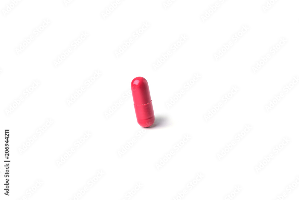 Red medical pills or capsules on white table with reflection.Red medical pills isolated over white background. Red medical pills or capsules on white table with reflection.Red medical pills isolated over white background.