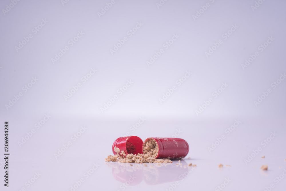 Red medical pills or capsules on white table with reflection.Red medical pills isolated over white background. Red medical pills or capsules on white table with reflection.Red medical pills isolated over white background.