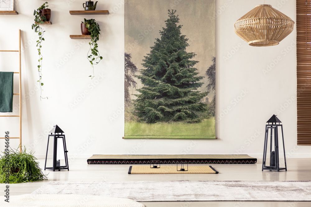 Obraz premium Tree painting on the wall, lamps, plants, tatami mat and mattress in a Japanese room interior
