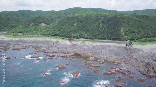 Aerial, rising on Wakayama coastline to reveal mountains. photo