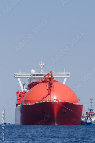 LNG TANKER - A big red ship with tugs
