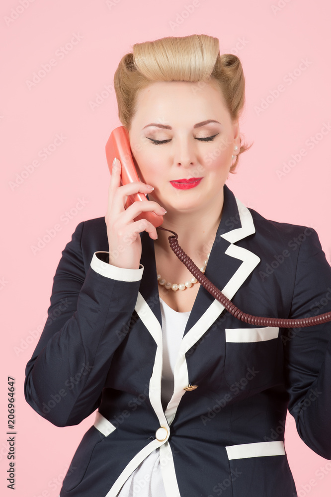 lifestyle and people concept: blonde woman is talking on the red phone receiver over rose background, closed eyes during conversation lifestyle and people concept: blonde woman is talking on the red phone receiver over rose background, closed eyes during conversation