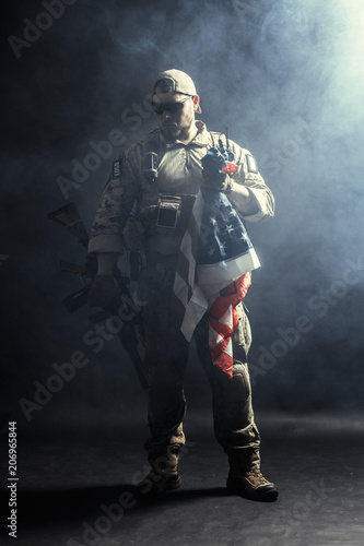Soldier holding machine gun with national flag