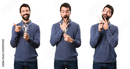 Set of Surprised Handsome brunette man with beard holding a bulb