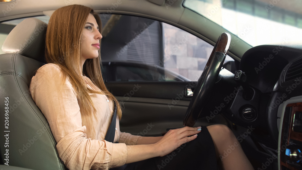 Confident businesslady sitting in just bought car, comfortable driver seat