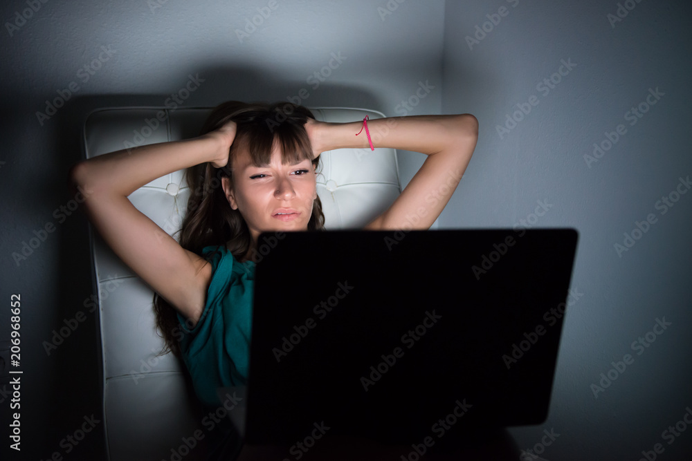 Frustrated young girl in the night with laptop Frustrated young girl in the night with laptop