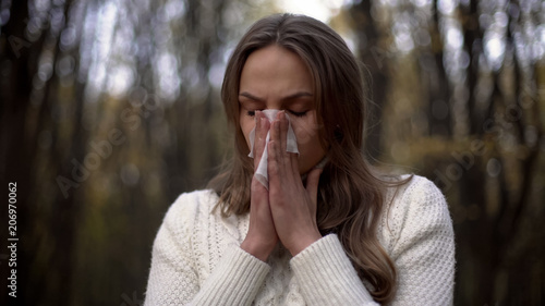 Lady sneezing and blowing her nose into napkin, seasonal allergies, epidemic