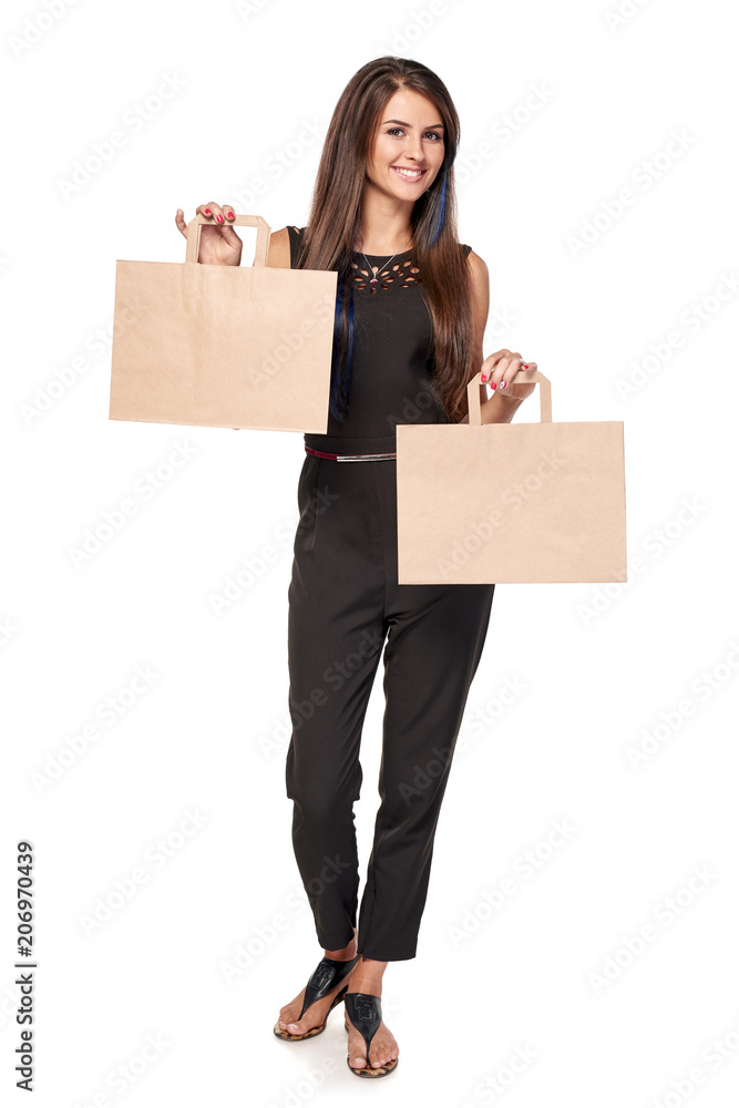 Smiling woman standing in full length with two carton brown shopping bags with empty copy spaces, isolated on white background Smiling woman standing in full length with two carton brown shopping bags with empty copy spaces, isolated on white background