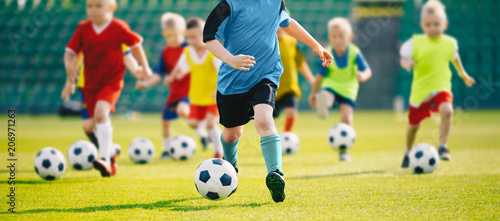 Trening piłkarski dla dzieci. Trening piłkarski dla dzieci. Dzieci biegają i kopią piłki. Młodzi chłopcy doskonalą umiejętności piłkarskie