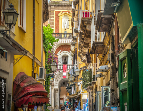 Narrow alley with Duomo steeple on the background in Sorrento