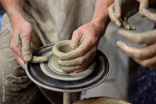 Potter teaches the student pottery in the workshop. Pottery, family craft. Collaboration.