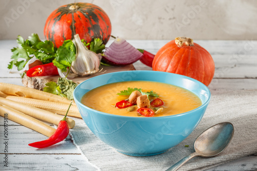 Spicy pumpkin soup with chili pepper in bowl