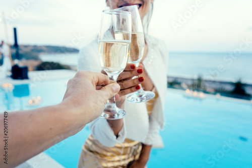 Frau und Mann stoßen an auf Pool und Strandparty