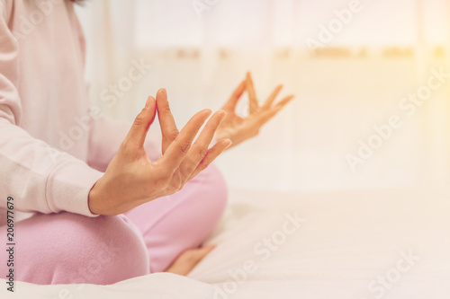 Asian women play yoga on bed in morning.color tone