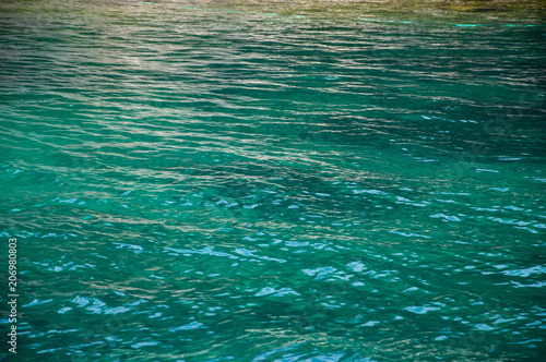 Turquoise sea surface with waves. Vignette.