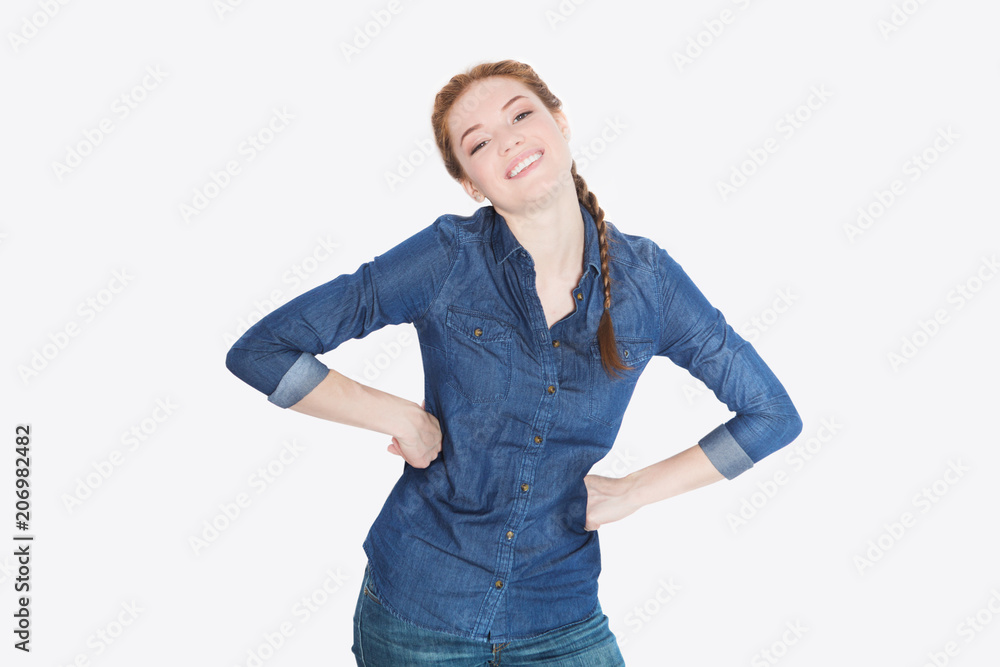 Beautiful cheerful teenage girl in a jeans shirt looking and smiling at camera on white background. Beautiful cheerful teenage girl in a jeans shirt looking and smiling at camera on white background.