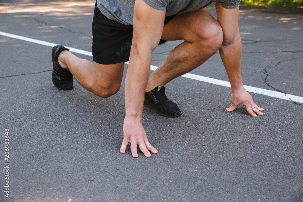 Cropped image of sportsman ready to start running Cropped image of sportsman ready to start running