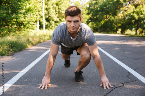 Confident sportsman ready to start running on a road