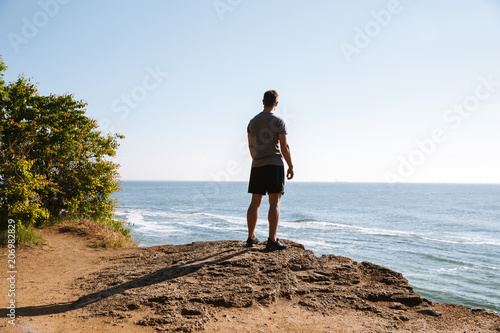 Young sportsman standing at the seashore and looking © Drobot Dean