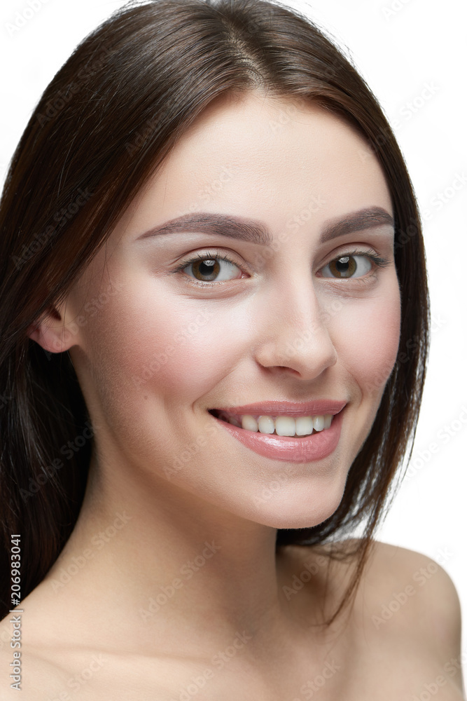 Close up of a girl with light day make up looking at camera. model having beatiful face with nice smile, plump lips, big eyes, white teeth. Dark brown hair, opened shoulders. White studio background. Close up of a girl with light day make up looking at camera. model having beatiful face with nice smile, plump lips, big eyes, white teeth. Dark brown hair, opened shoulders. White studio background.