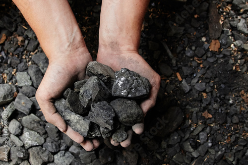 Coal miner in the man hands of coal background. Coal mining or energy source, environment protection. Industrial coals. Volcanic rock.