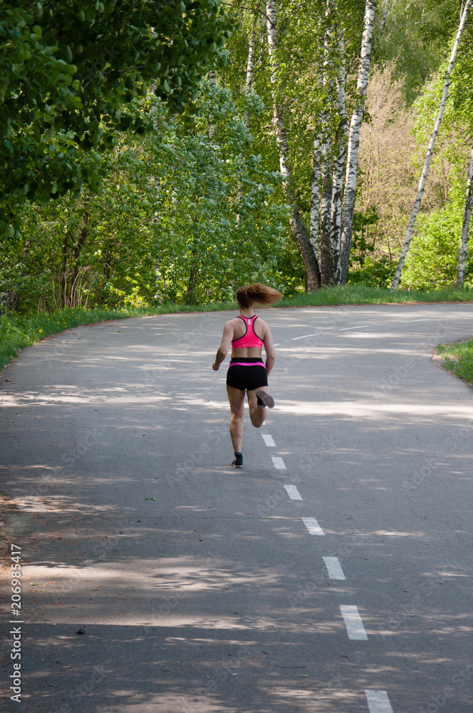 Beautiful smiling woman running in the park in the morning. Fitness girl running in the park. Running woman. Female Runner Jogging during Outdoor Workout in a Park. Beautiful fit Girl. Beautiful smiling woman running in the park in the morning. Fitness girl running in the park. Running woman. Female Runner Jogging during Outdoor Workout in a Park. Beautiful fit Girl.