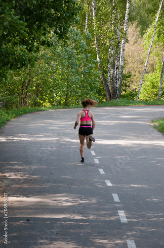 Beautiful smiling woman running in the park in the morning. Fitness girl running in the park. Running woman. Female Runner Jogging during Outdoor Workout in a Park. Beautiful fit Girl.