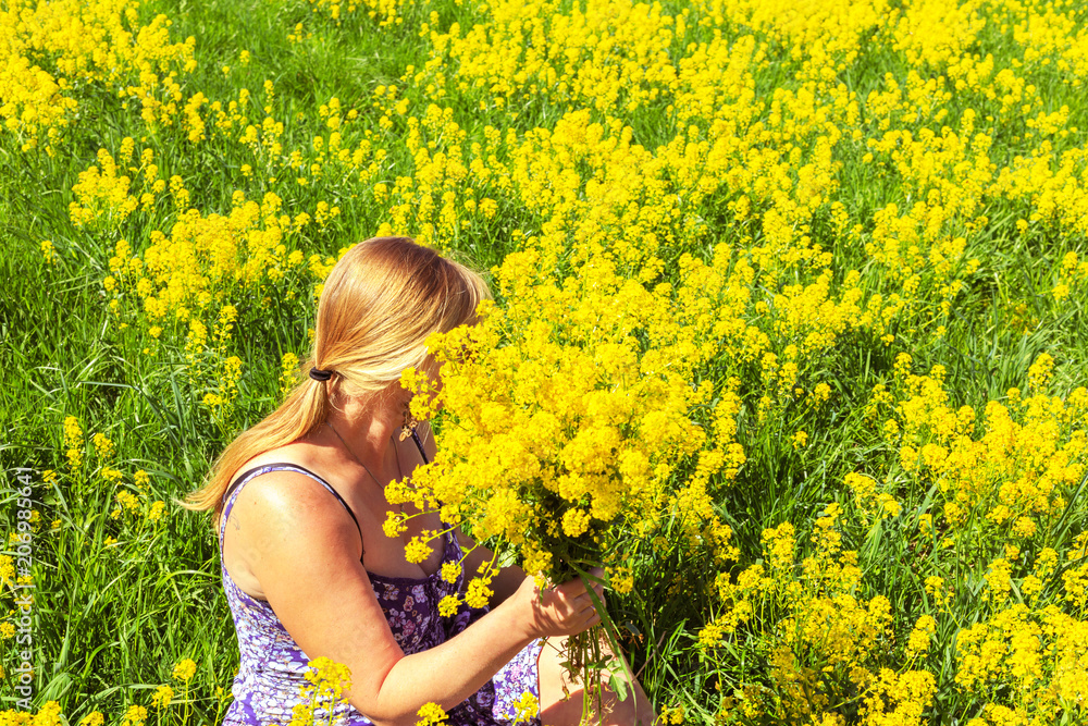 Happy blonde enjoys nature in a yellow field. Happy blonde enjoys nature in a yellow field.