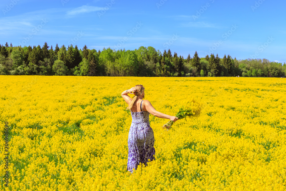 Fototapeta premium Girl running across the yellow field.