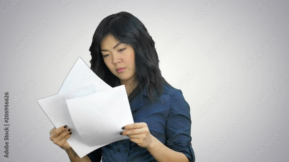 Asian business women looking document file in her hand on white background Asian business women looking document file in her hand on white background
