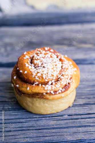 kanelbulle med pärlsocker på rustik trä bakgrund photo