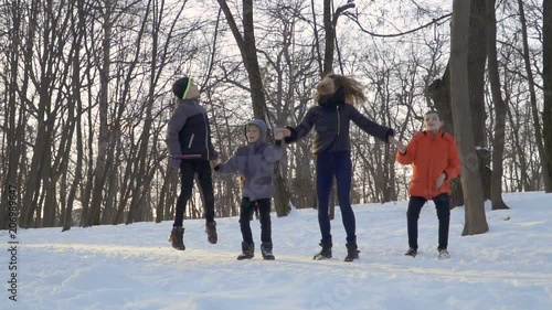 Young woman with her sons jump together in slow motion photo