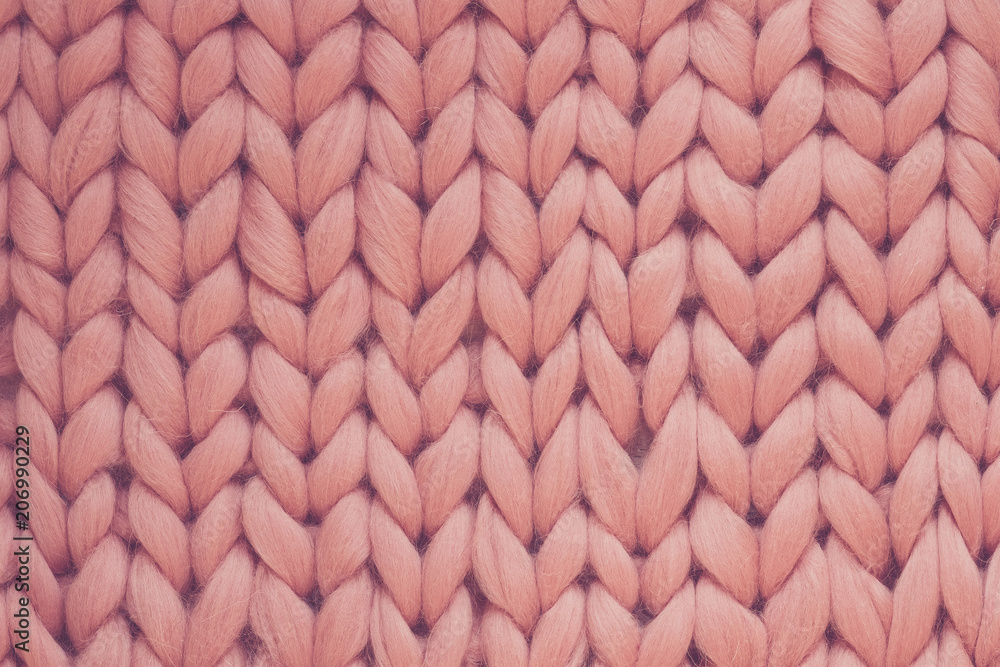 Texture of pink knit blanket. Large knitting. Plaid merino wool. Top view Texture of pink knit blanket. Large knitting. Plaid merino wool. Top view